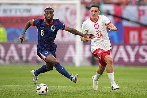 Georginio Wijnaldum challenges for the ball with Bartosz Slisz